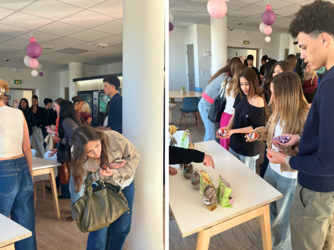 Deux photos côte à côte montrent un groupe de jeunes adultes réunis dans une salle lumineuse décorée de lampions en papier rose et blanc suspendus au plafond. Ils font la queue et se servent des bonbons ou chocolats disposés sur une table. L'ambiance semble conviviale et décontractée, évoquant un moment de partage ou une pause goûter collective.